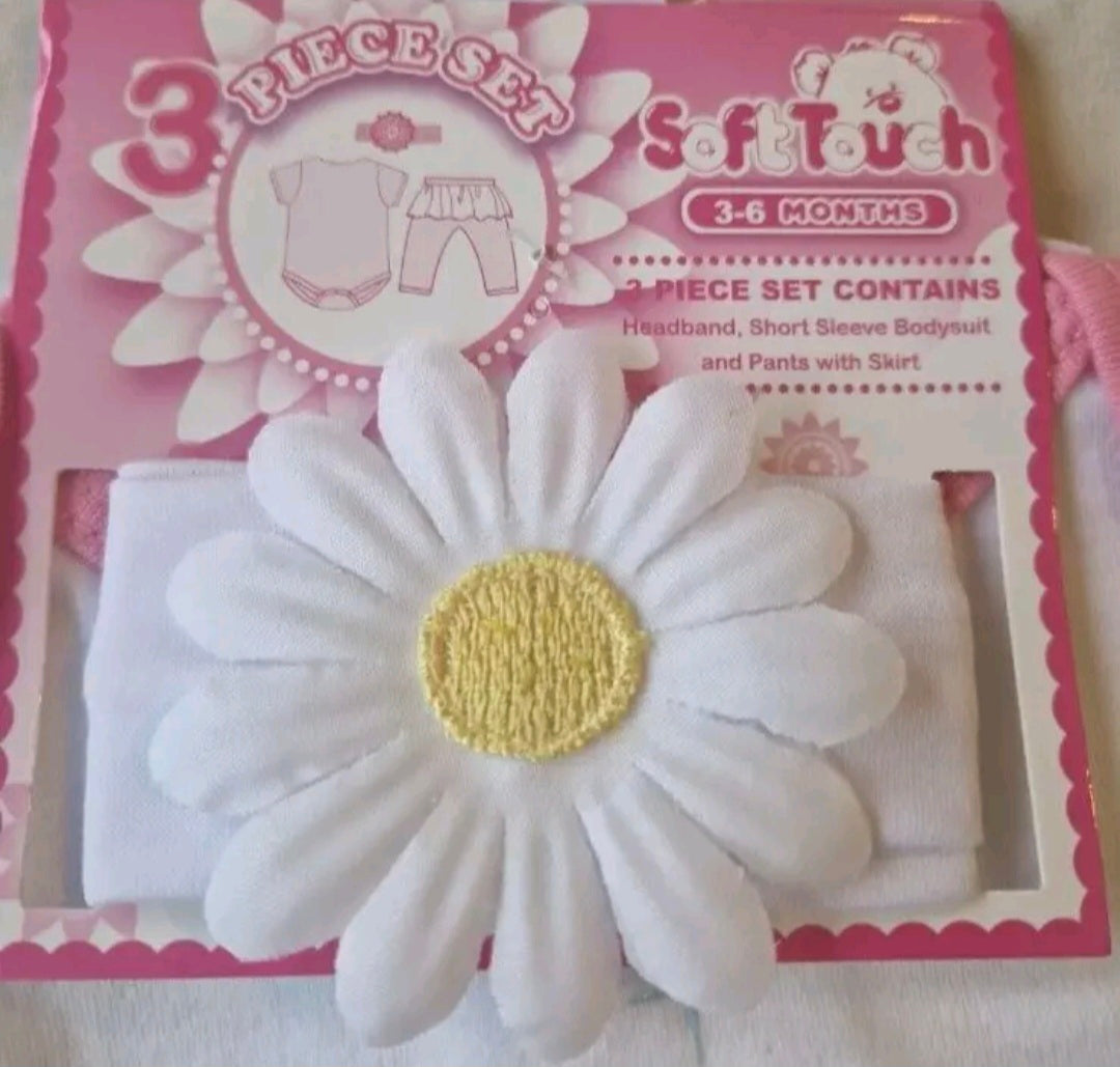 Baby headband with daisy design in front of a pink packaging box