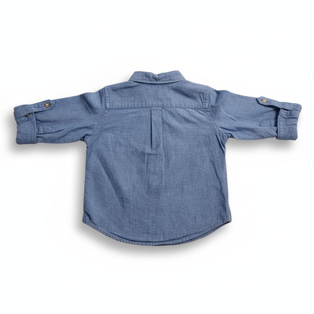 Blue denim shirt with rolled-up sleeves on a white background