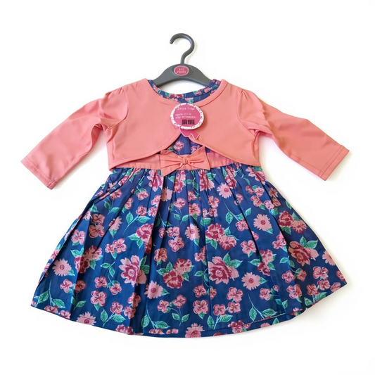 Children's dress with pink jacket on a hanger against a white background
