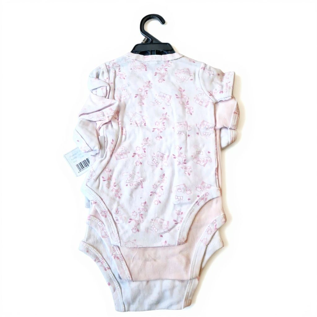 Baby onesie with pink floral pattern on a hanger against a white background