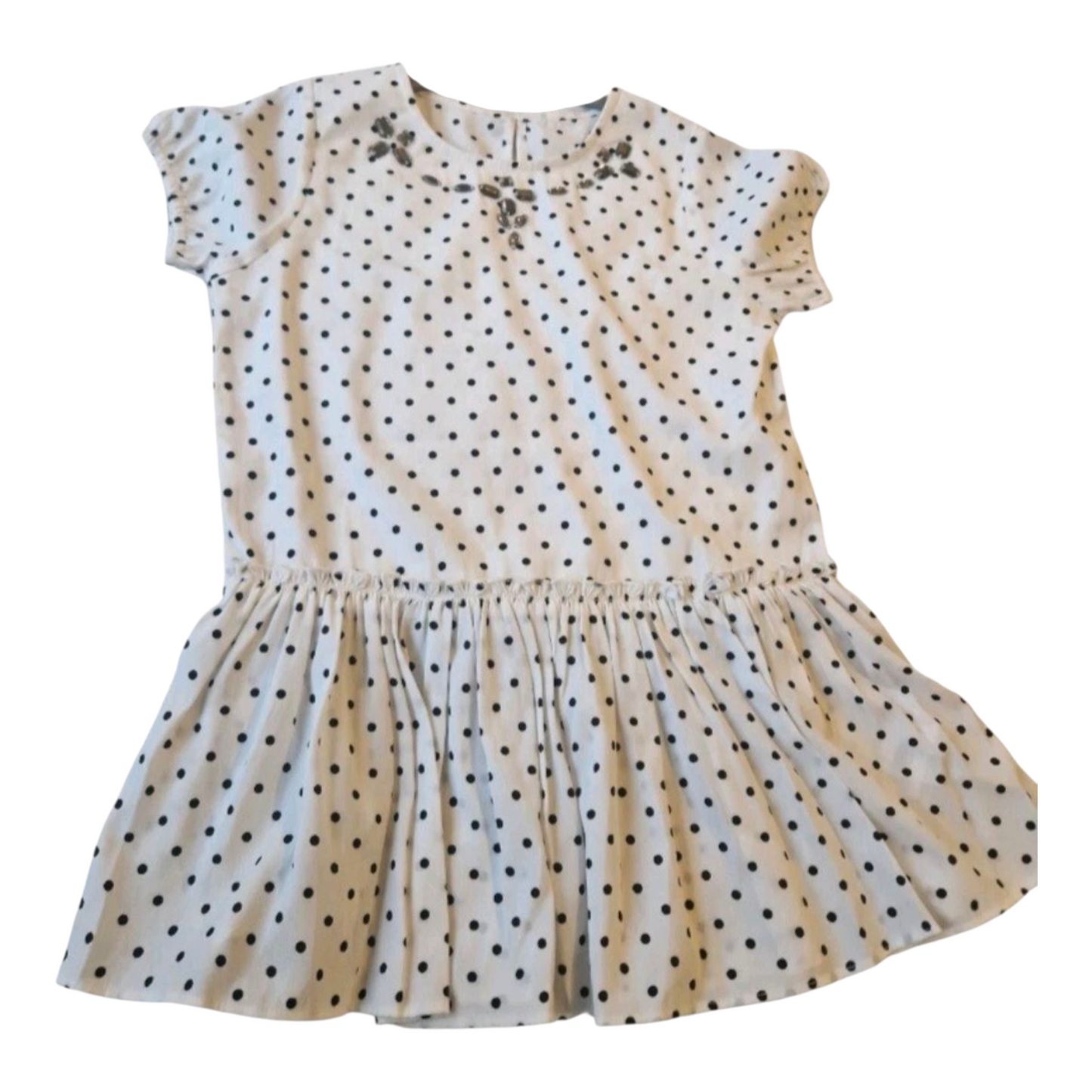Beige dress with black polka dots on a white background