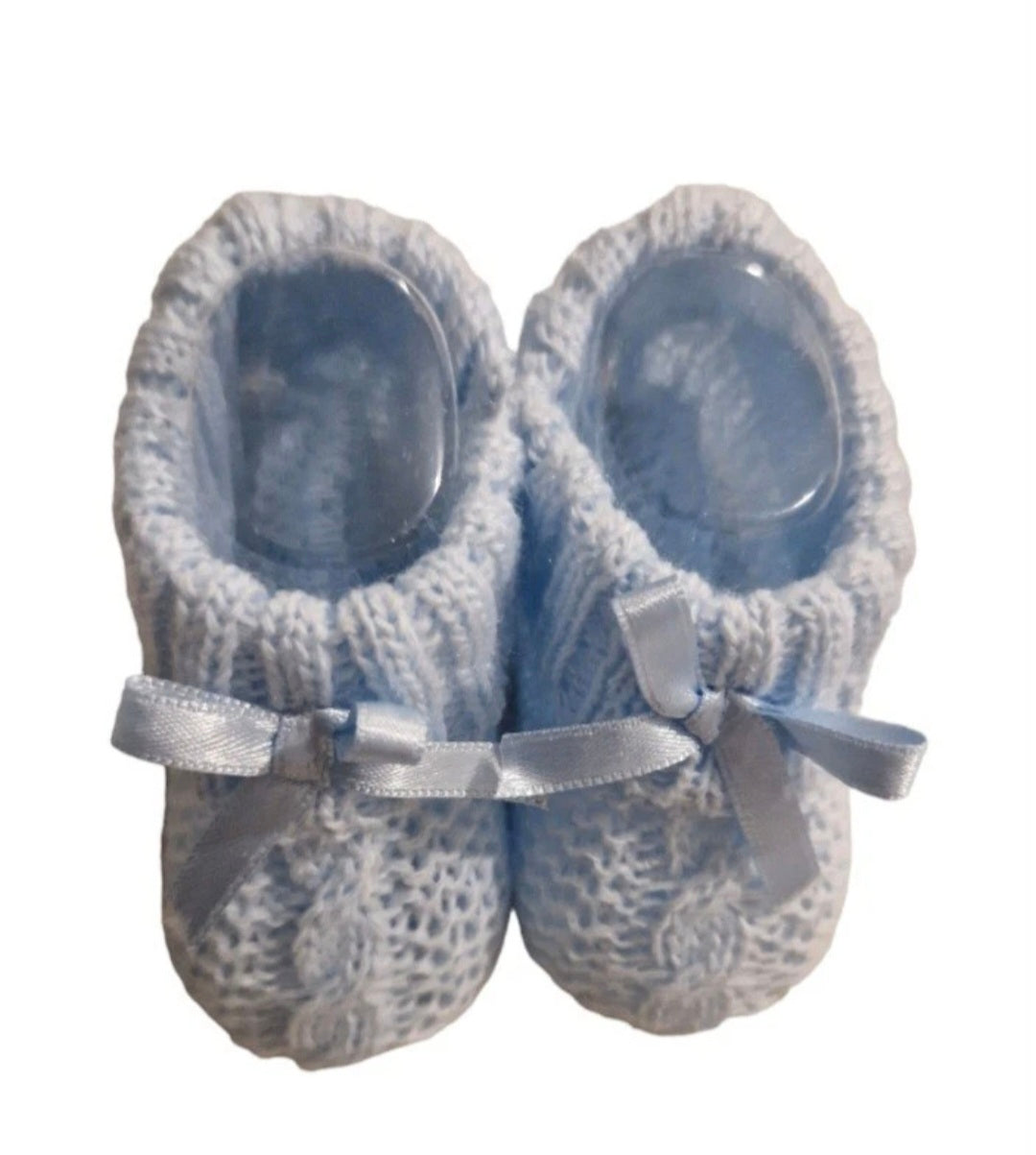 Pair of blue baby shoes with ribbons on a white background