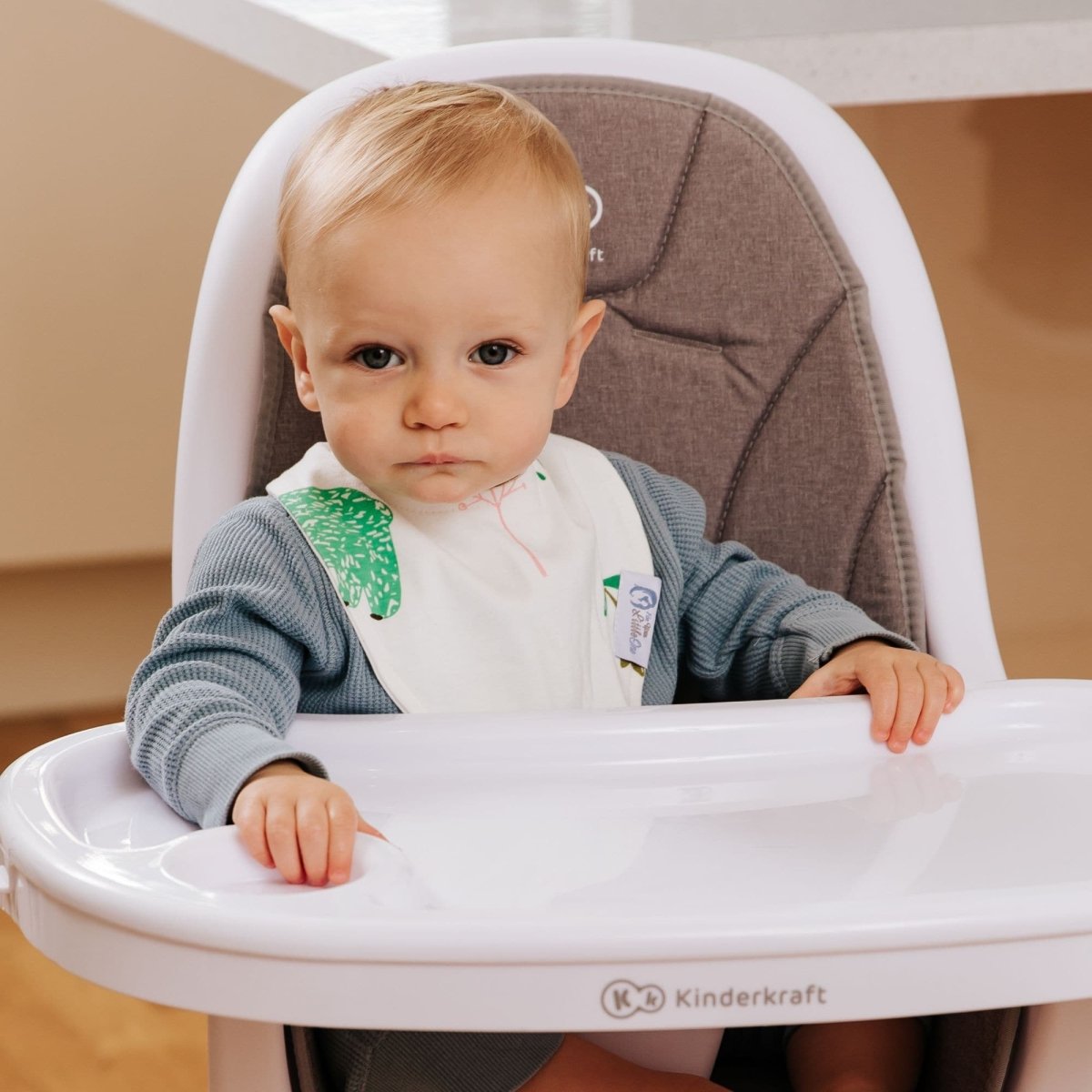 Child in a high chair with a Kinderkraft brand label