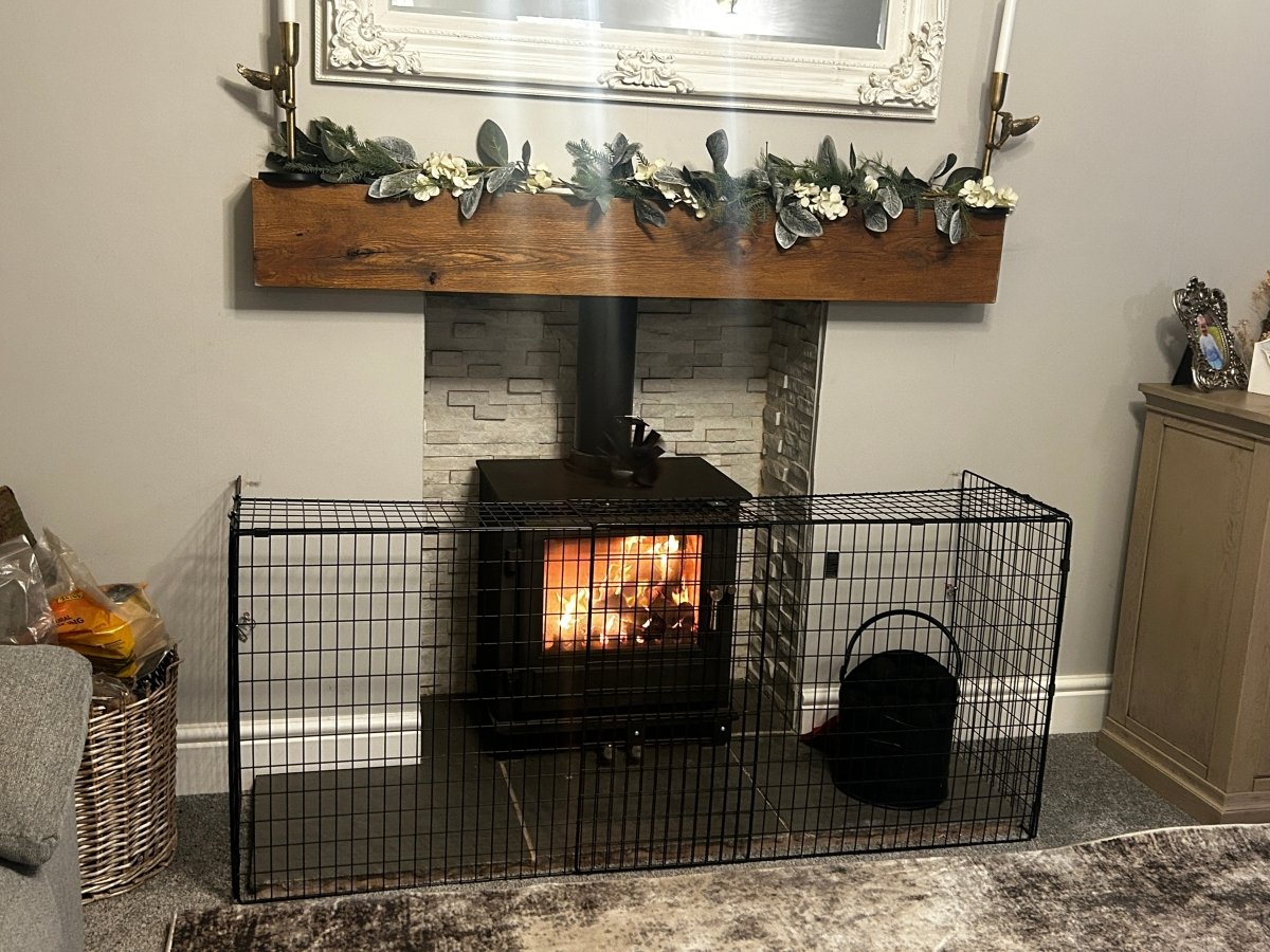 Wood-burning stove with decorative mantel and festive decorations in a living room.