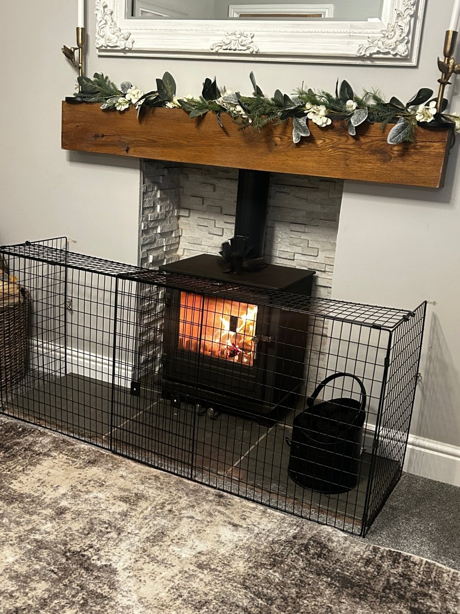Wood-burning stove with decorative mantel and wire cage in a room.