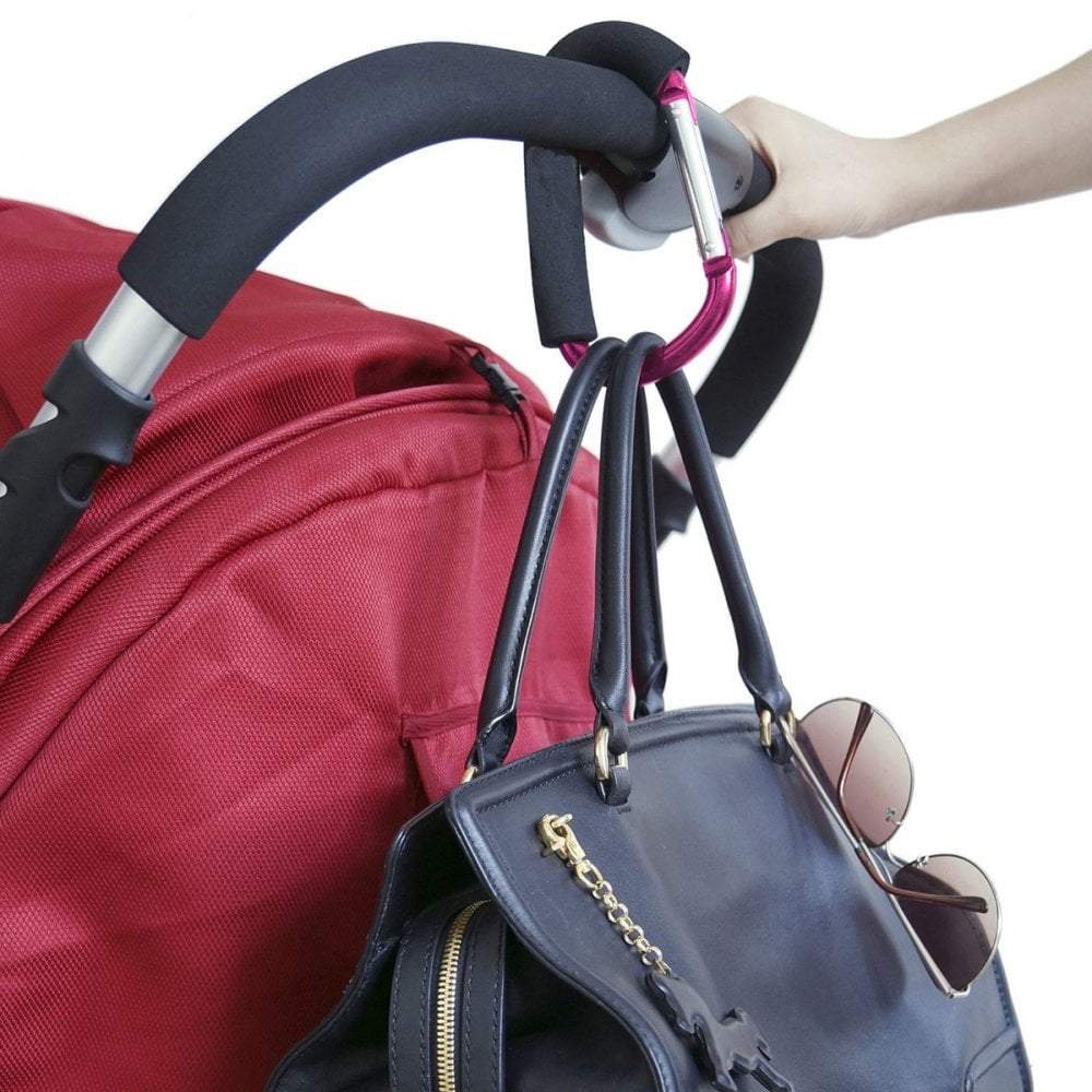 Hand holding a black handbag with sunglasses attached to a red stroller handle.