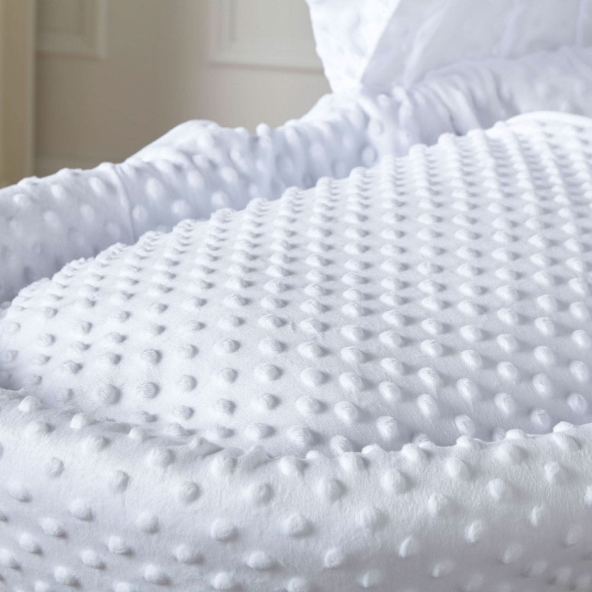 Close-up of a textured white blanket on a bed