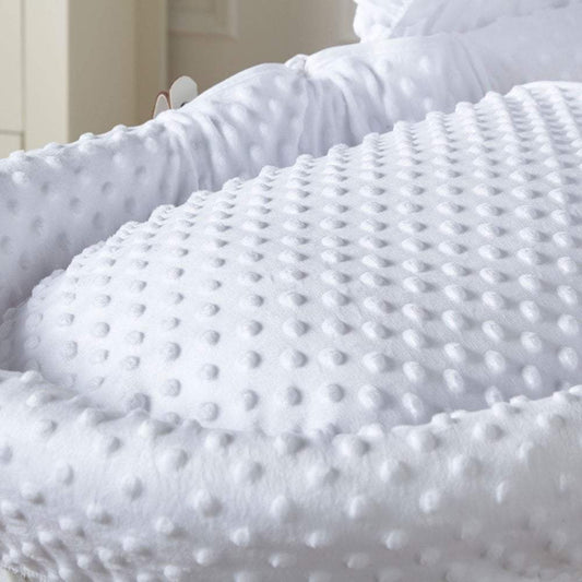 Close-up of a textured white blanket with a soft, plush surface.